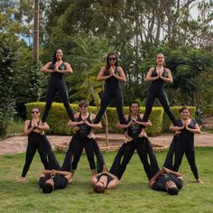 a group of women doing yoga poses on the grass