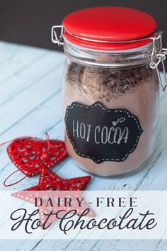 hot cocoa in a glass jar next to two red ornaments