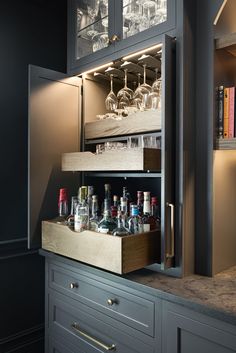 an open cabinet filled with bottles and glasses