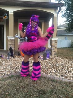 a woman dressed in pink and purple is standing outside