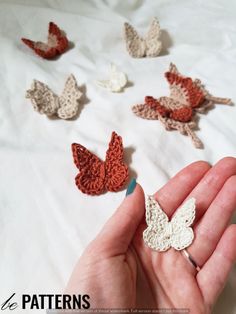 crocheted butterflies are being held in someone's hand