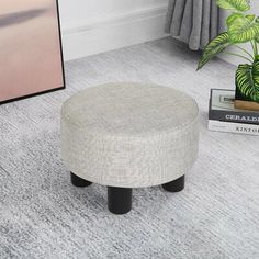 a white ottoman sitting on top of a carpeted floor next to a potted plant