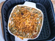 a casserole dish with green beans, onions and cheese in it on a plastic tray