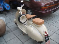 a scooter is parked next to a car