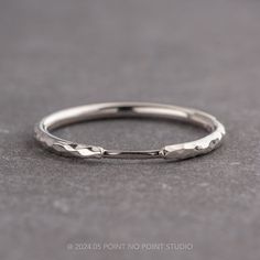 a close up view of a wedding ring on a gray surface with the word love written across it