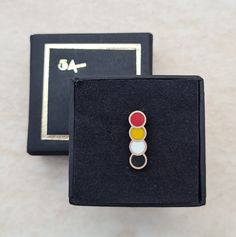 a pair of rings sitting on top of a black box next to a white and red object