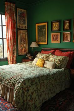 a bedroom with green walls and pictures on the wall above the bed, along with an area rug