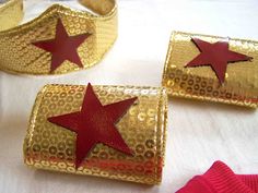 gold and red bracelets with stars are on a white tablecloth next to pink socks