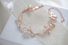 This delicate Rose gold cubic zirconia cuff bracelet for bride is inspired by nature with it's lovely leaf design. Perfect for a bridal look or any special occasion.- Crafted with Swarovski Pure Brilliance components.- All clear stones- Rhodium, yellow gold or rose gold finish- Bracelet measures 6.5 inches and extends Gold Bridesmaid Bracelet, Bracelet For Bride, Gold Infinity Bracelet, Bridal Backdrop Necklace, Bridal Bracelet Pearl, Rose Gold Wedding Jewelry, Pearl Bracelet Wedding, Gold Backdrop, Backdrops Necklace