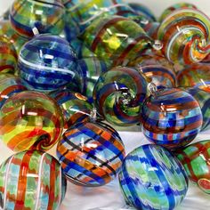 many different colored glass balls on a white surface