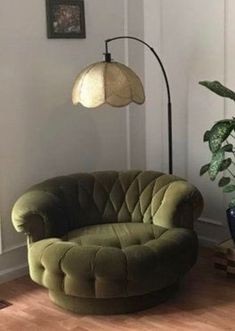 a living room with a green chair and potted plant