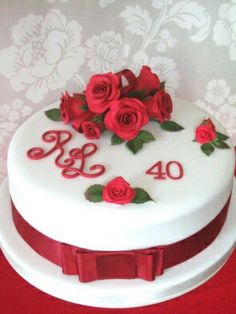 a white cake with red roses on top and the number forty four written in cursive letters