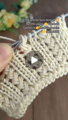 someone is crocheting the side of a piece of white yarn with a needle