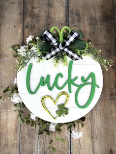 a wooden sign that says lucky with shamrocks and hearts in the shape of a heart