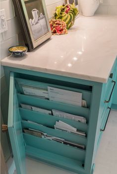 a cabinet with many files in it and a bowl of fruit on the counter top