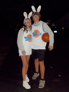 a man and woman in bunny ears standing next to each other with basketballs on their backs