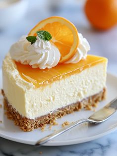 a slice of cheesecake with whipped cream and oranges on top is sitting on a plate