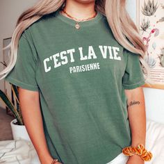 "Looking for a comfortable and stylish travel shirt that captures the essence of Parisian life? Look no further than this \"C'est la vie Parisienne\" t-shirt. Made from soft and breathable cotton, this shirt is perfect for exploring the City of Light or simply lounging in style. Featuring a bold and retro style design, this French saying t-shirt is the perfect way to add some Parisian flair to your wardrobe. The phrase is printed in white against a black background, making it stand out and grab Youth Pastor Gifts, Pastor Wife, Preachers Wife, Life In Paris, French Quote, Pastor's Wife, Pastor Appreciation, Paris Shirt, Pastors Appreciation