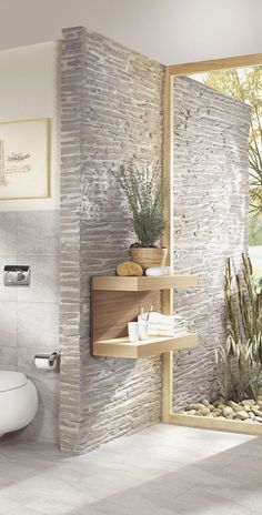 a bathroom with a toilet and stone wall