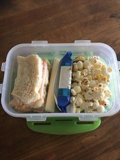 a plastic container filled with food on top of a wooden table