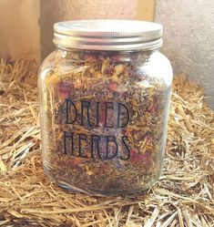 a jar filled with dried herbs sitting on top of straw