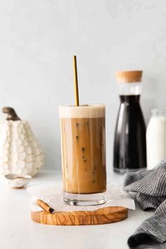 an iced drink in a glass with a straw on the top and some cinnamon sticks next to it