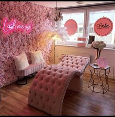 a room with pink furniture and flowers on the wall