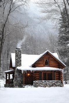 a log cabin in the middle of winter with snow on the roof and chimneys