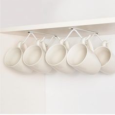 five white coffee cups hanging from the ceiling