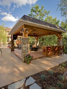 an outdoor kitchen and dining area in a backyard