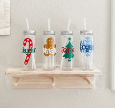 three personalized christmas tumblers on a shelf