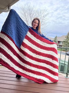 a woman holding an american flag crocheted blanket