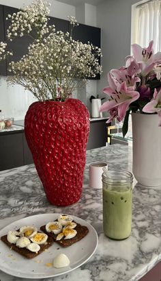 there is a vase with flowers in it next to some food on the counter top