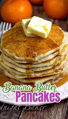 pancakes on a plate with butter and oranges in the backgroung background