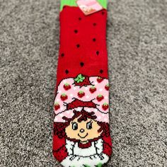 a pair of socks that have strawberrys on them and a girl in the middle