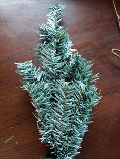 a small christmas tree sitting on top of a wooden table next to a pair of scissors