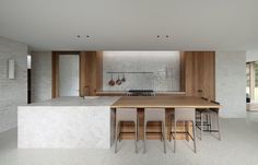 a modern kitchen with an island countertop and bar stools