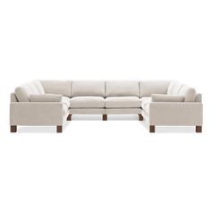 a white sectional couch with wooden legs