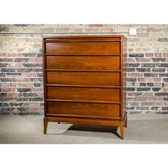 a wooden dresser sitting in front of a brick wall