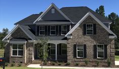 a brick house with black shutters and white trim