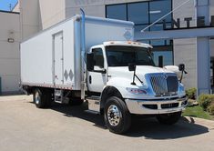 a large white truck parked in front of a building