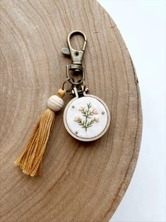 a keychain with a small embroidered flower on it