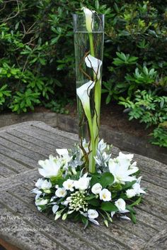 a vase filled with flowers sitting on top of a wooden table