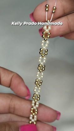 two hands holding a beaded bracelet with pearls and gold beads on the clasps