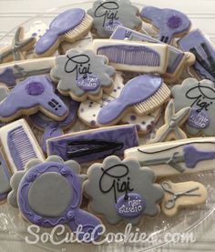 decorated cookies in the shape of scissors, combs and hairdryers on a plate