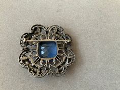 Beautiful blue stone brings brilliance to this old brooch. It measures 1.75 inches in width and length. Antique, and so pretty. Great gift for Mother's Day! Victorian Blue Brooch For Formal Occasions, Blue Victorian Brooch For Formal Occasions, Blue Victorian Brooches For Formal Occasions, Formal Blue Gemstone Brooch, Formal Blue Gemstone Brooches, Blue Gemstone Brooch For Anniversary, Blue Gemstone Brooches For Anniversary, Ornate Blue Brooch For Formal Occasions, Vintage Sapphire Brooch Jewelry