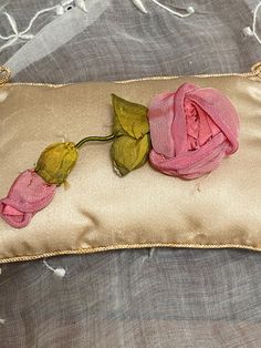 a rose on a pillow that is laying on a bed