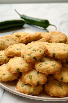 a white plate topped with cookies next to a green pepper