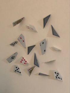 several pieces of playing cards are arranged in the shape of a triangle on a white wall