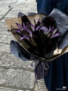 a woman holding a bouquet of purple flowers